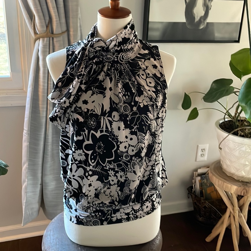 Fun, floral, sleeveless blouse with tie at neck & banded hem.